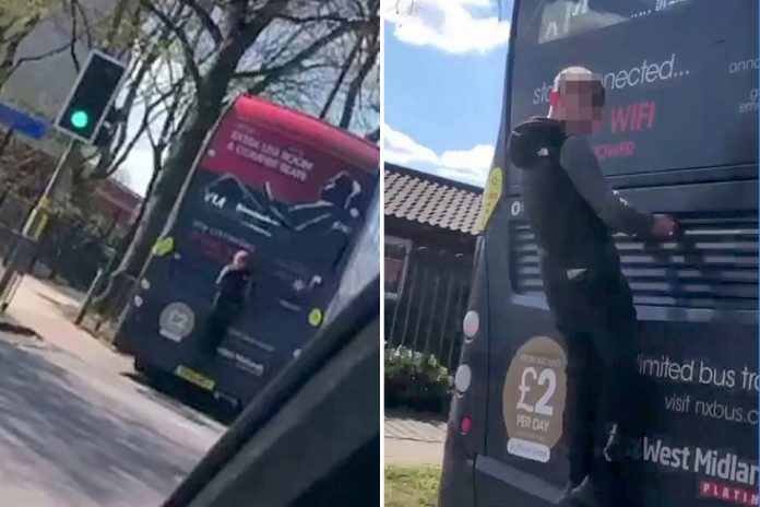 Idiot risks his life by clinging to the back of a bus that goes 30 miles an hour

